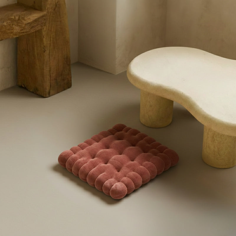 Brown Floor Cushion on a beige floor with a stone bench in the background