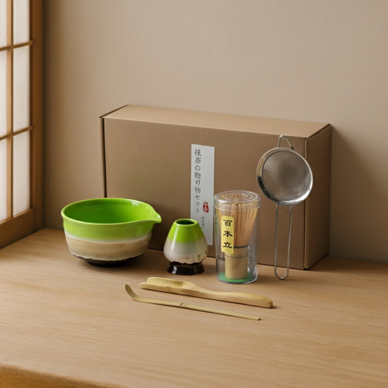 Ceramic Matcha Set with a green bowl, strainer, and other tools on a wooden surface.