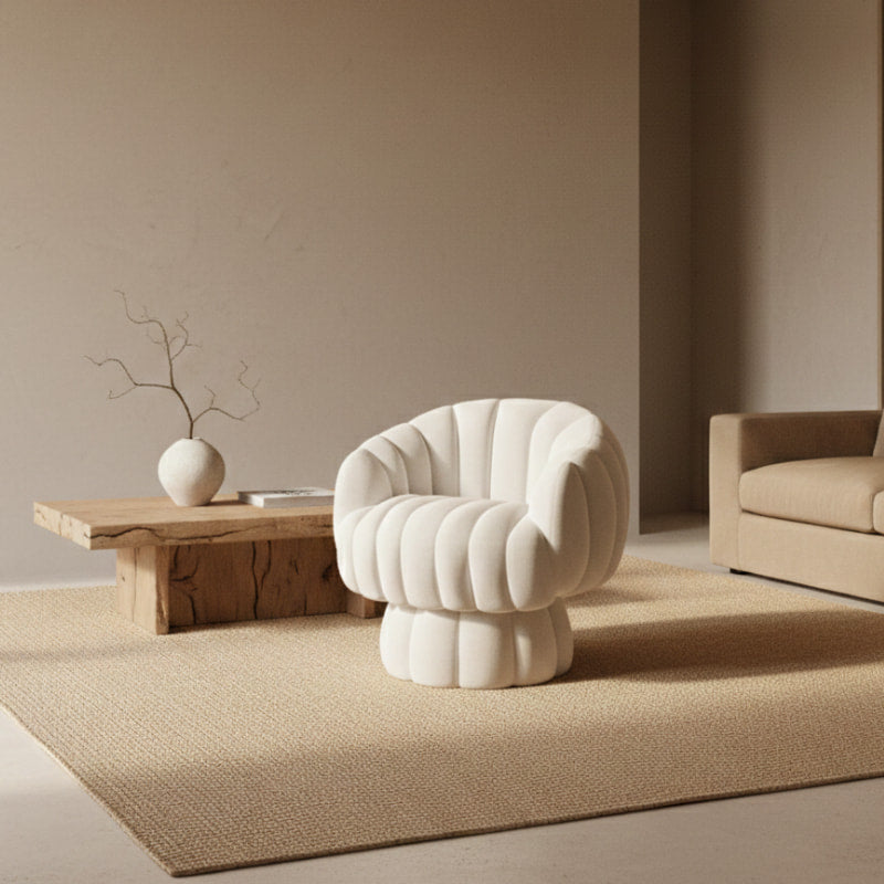 White Swivel Velvet Accent Chair next to a wooden side table with a bowl on a beige wall background