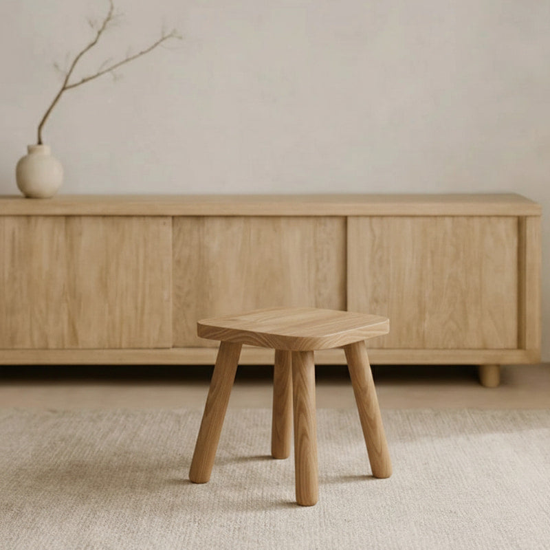 Wabi Sabi Stool in front of a wooden cabinet with a minimalistic background