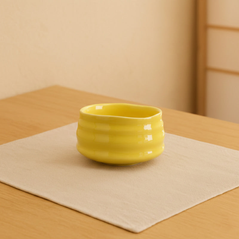 Yellow Matcha Bowl on a wooden table with a neutral background