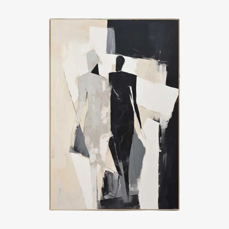 black and white modern wall art above a wooden table with a vase, next to a beige sofa.