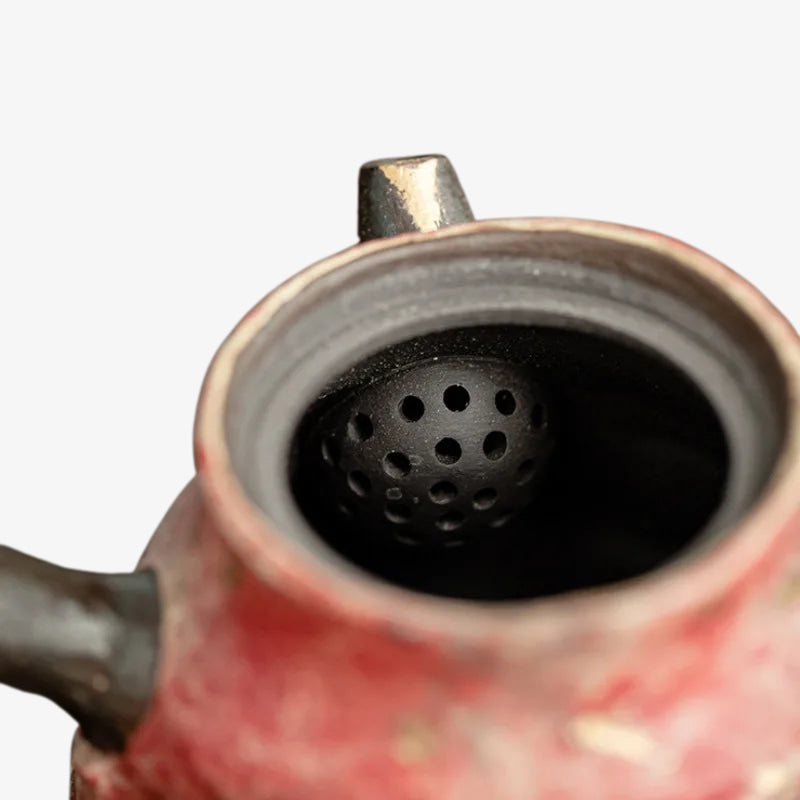 Close-up of a ceramic china teapot spout with a black interior