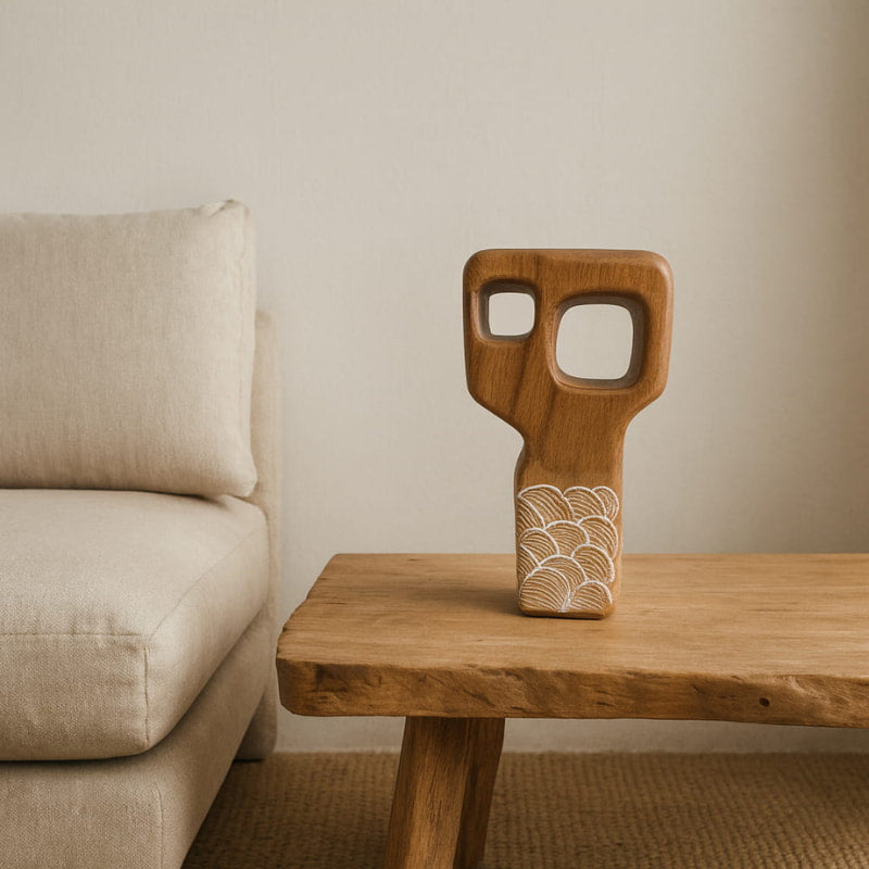 handmade wood decor with abstract design on a wooden table next to a beige sofa.