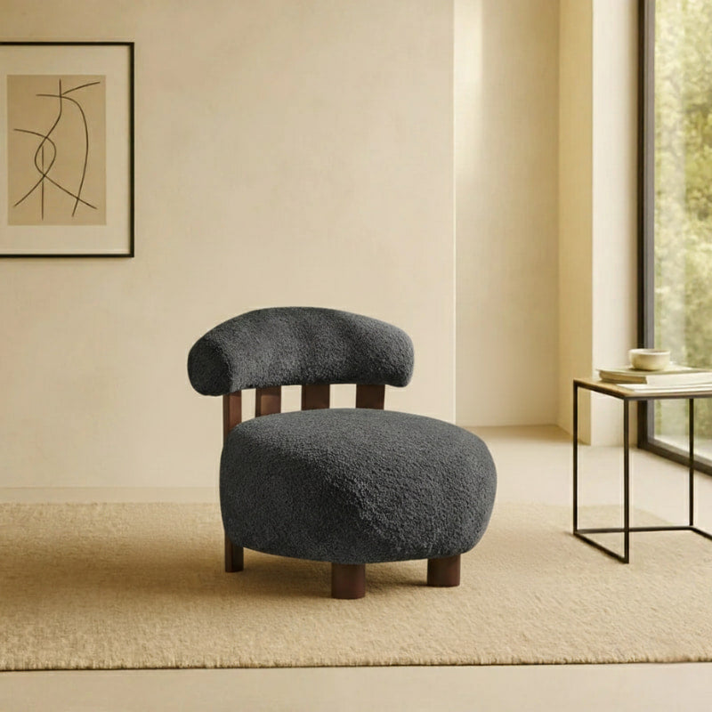 japandi style accent chair in a room with a abstract painting on the wall and a side table.
