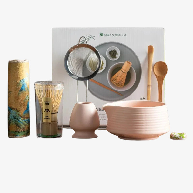 japanese ceremonial matcha green tea set with pink bowl, glass, and other utensils on a white background