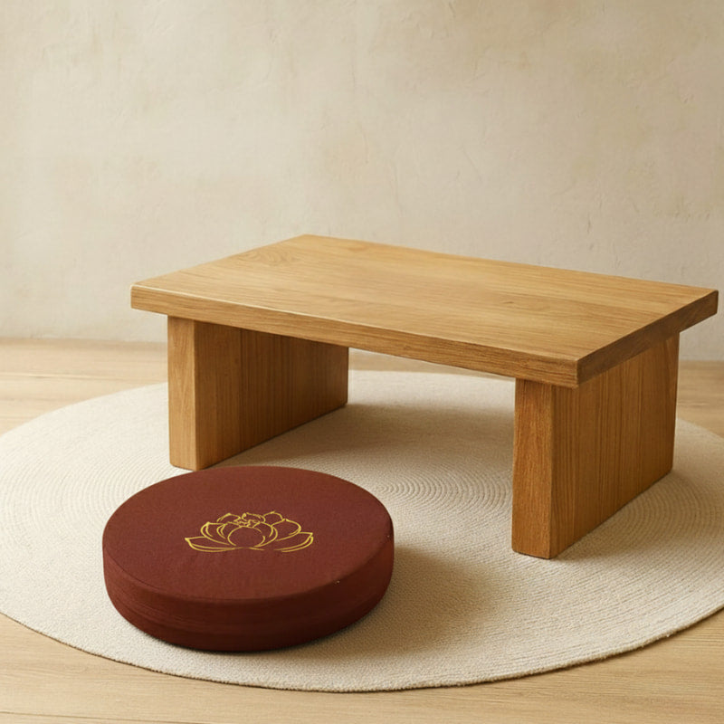 Wooden meditation bench with a large brown floor cushion featuring a lotus symbol on a beige background