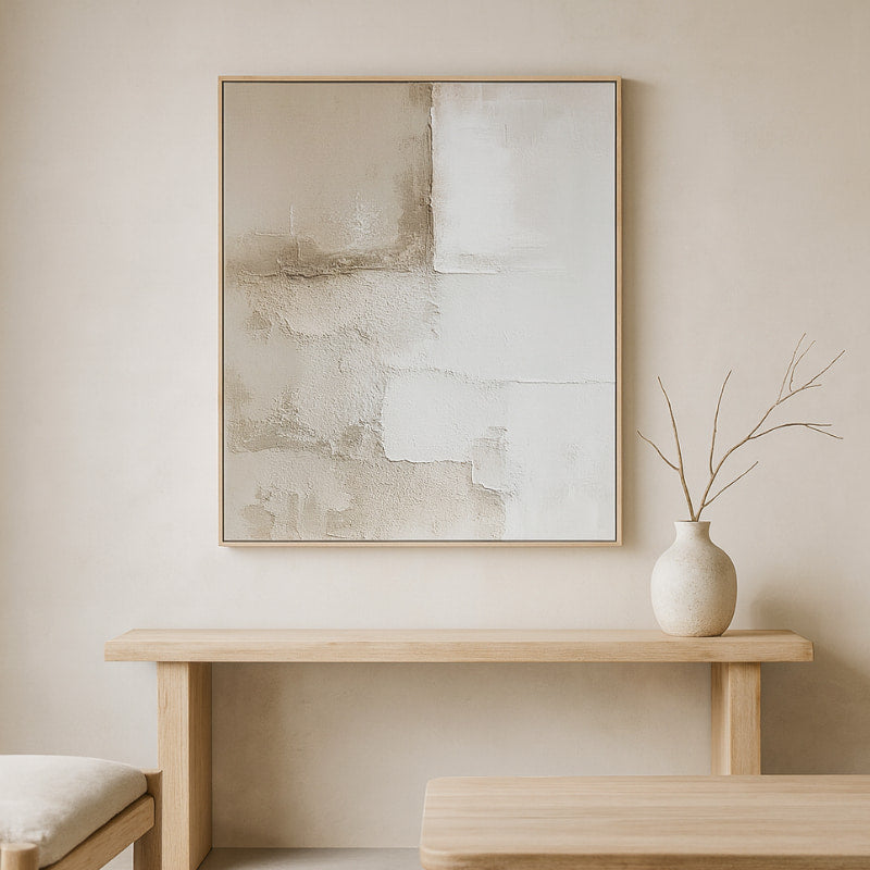 Minimalist interior with large modern wall art and a vase on a wooden table.