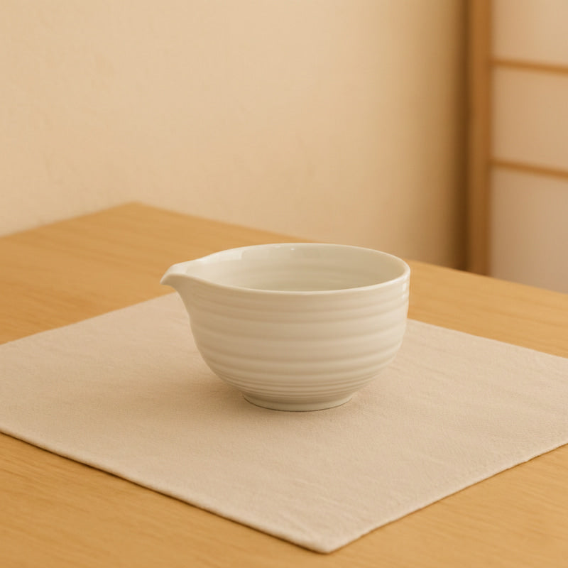 matcha bowl white on a wooden surface with a beige background