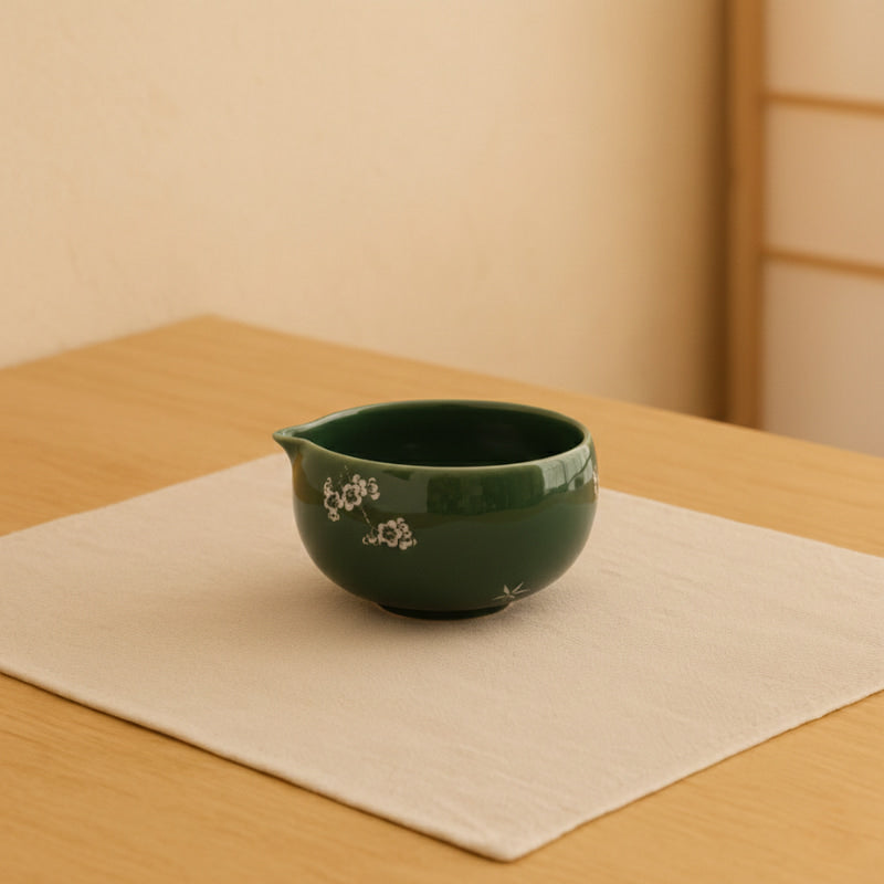 matcha green tea bowl with floral design on a beige surface