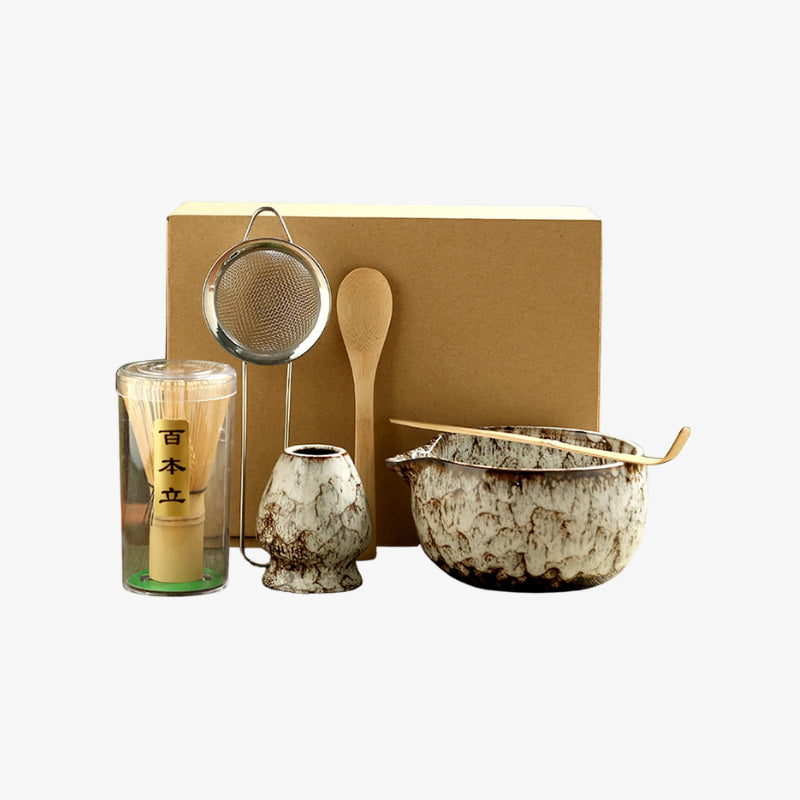 matcha set ceremonial grade with ceramic bowls, glass, and wooden spoon on a white background