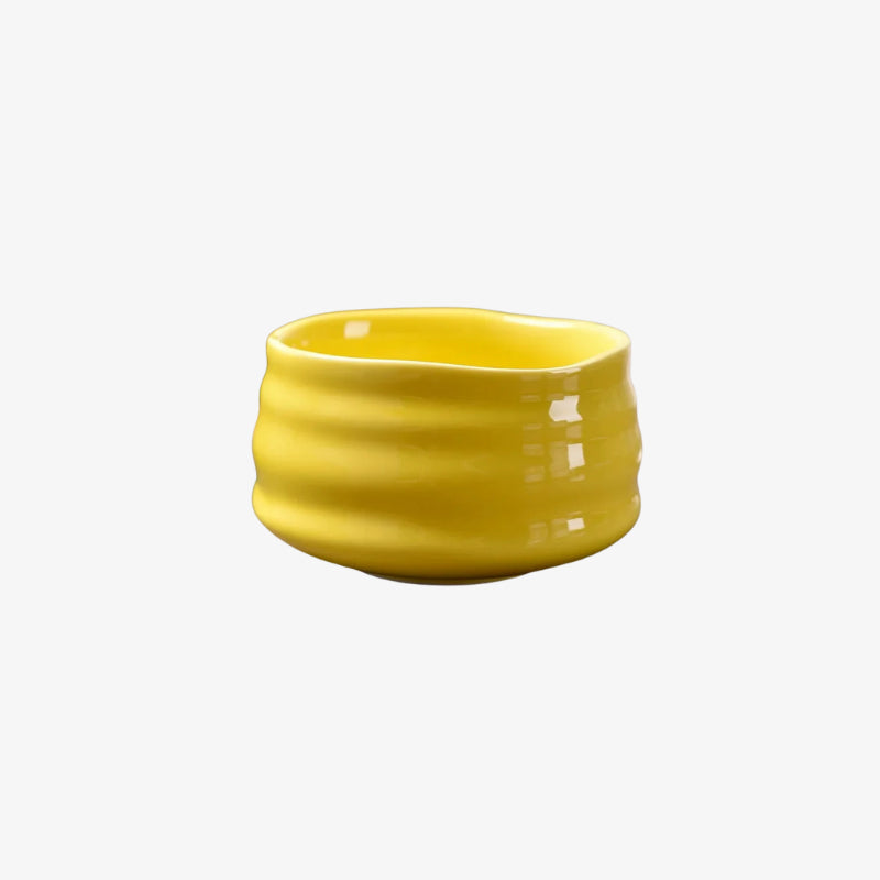 Yellow raku tea bowl designs on a white background