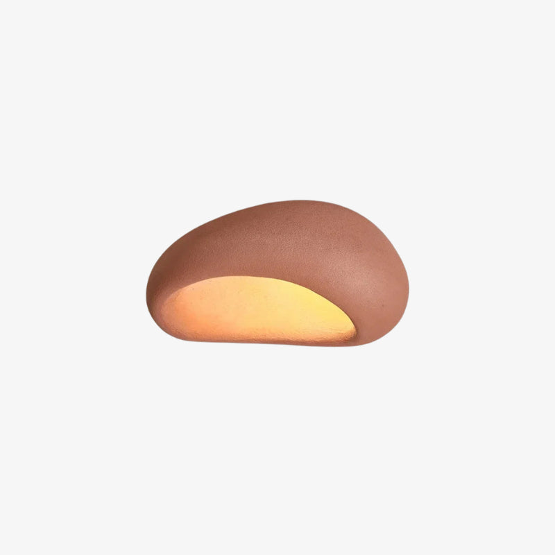 Cylindrical round pink lamp with a warm glow on a white background