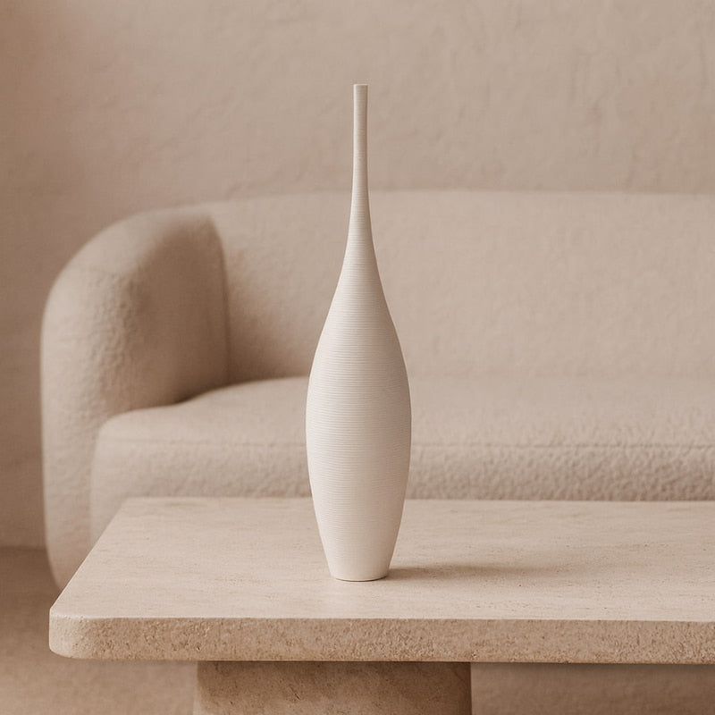 Tall decorative vase on a beige table with a neutral background