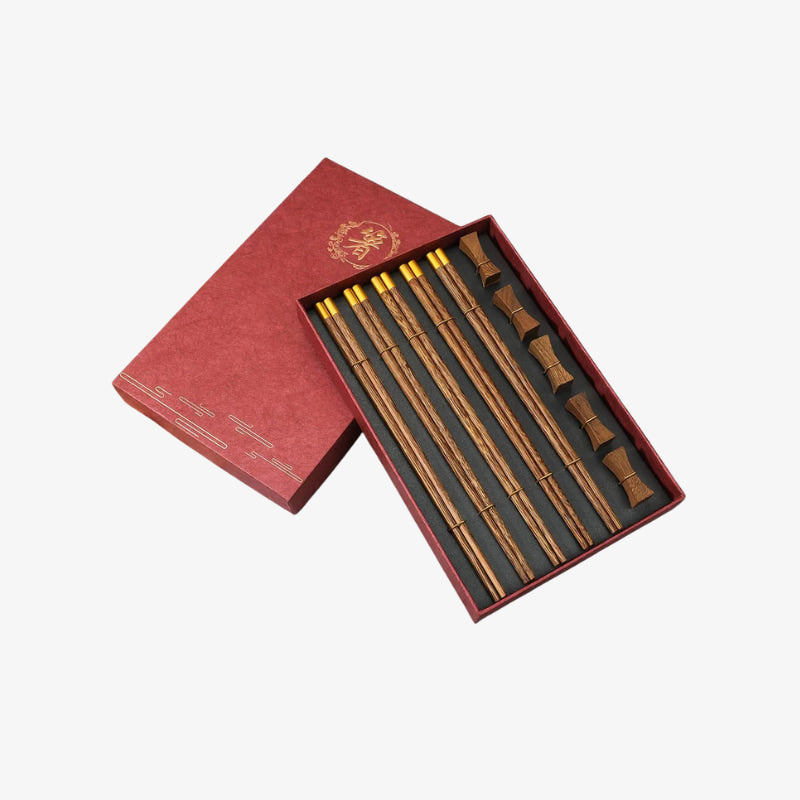Chopstick and wooden chopstick holder in a red box on a white background