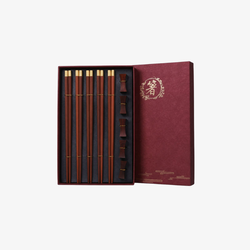 Chopstick and wooden chopstick holder in a red box on a white background
