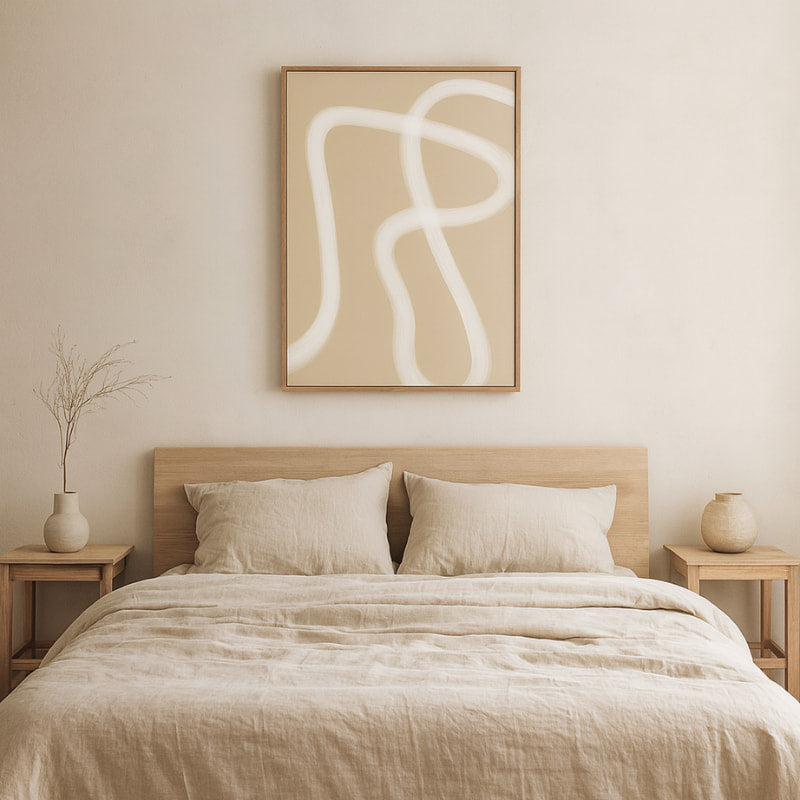 Beige bedroom with zen wall art prints, bed, and side tables.