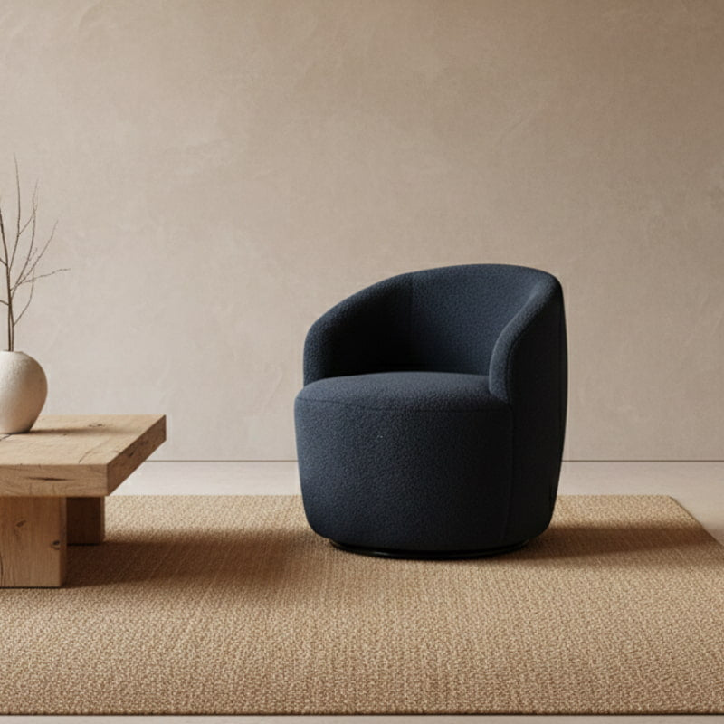 Blue Boucle Swivel Chair in a minimalistic room with a stone sculpture on a beige wall.