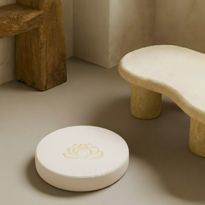 Blue Lotus Meditation Cushion with a floral design on a beige surface next to a stone stool.