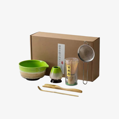 Ceramic Matcha set green with a bowl, whisk, scoop, and other tools in front of a cardboard box.