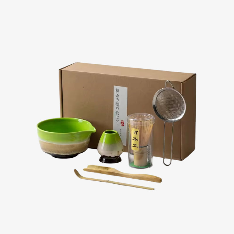 Ceramic Matcha set green with a bowl, whisk, scoop, and other tools in front of a cardboard box.