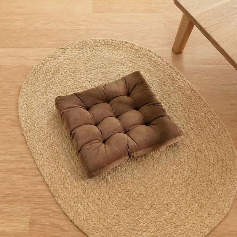 Brown Floor Cushion Coffee Table on a woven mat in a room with wooden flooring.