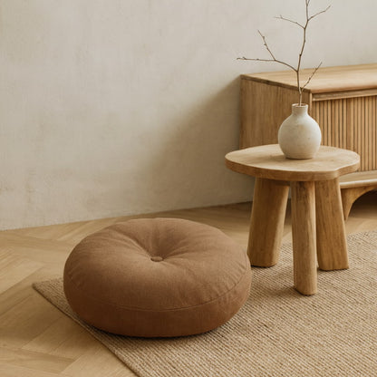 Brown Japanese Sitting Cushion on a wooden floor with a small wooden table and vase in the background.