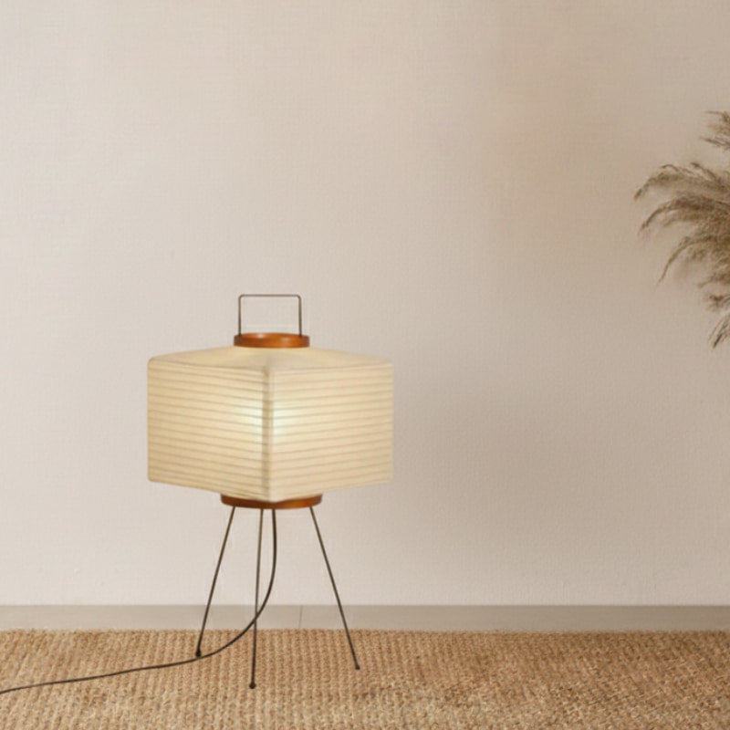 Modern floor lamp with a woven shade on a tripod base in a minimalistic room.