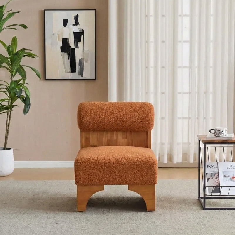 Orange Round Back Chair in a living room setting with a plant and artwork on the wall.