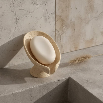Beige soap holder on a textured surface with a stone wall background