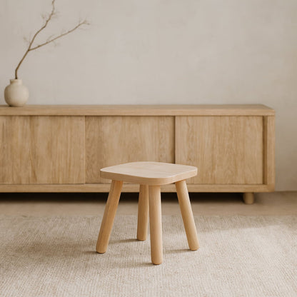 Wabi Sabi Stool in front of a wooden cabinet with a minimalistic background