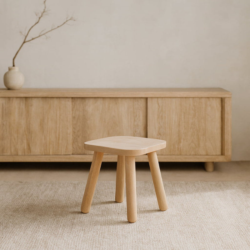 Wabi Sabi Stool in front of a wooden cabinet with a minimalistic background