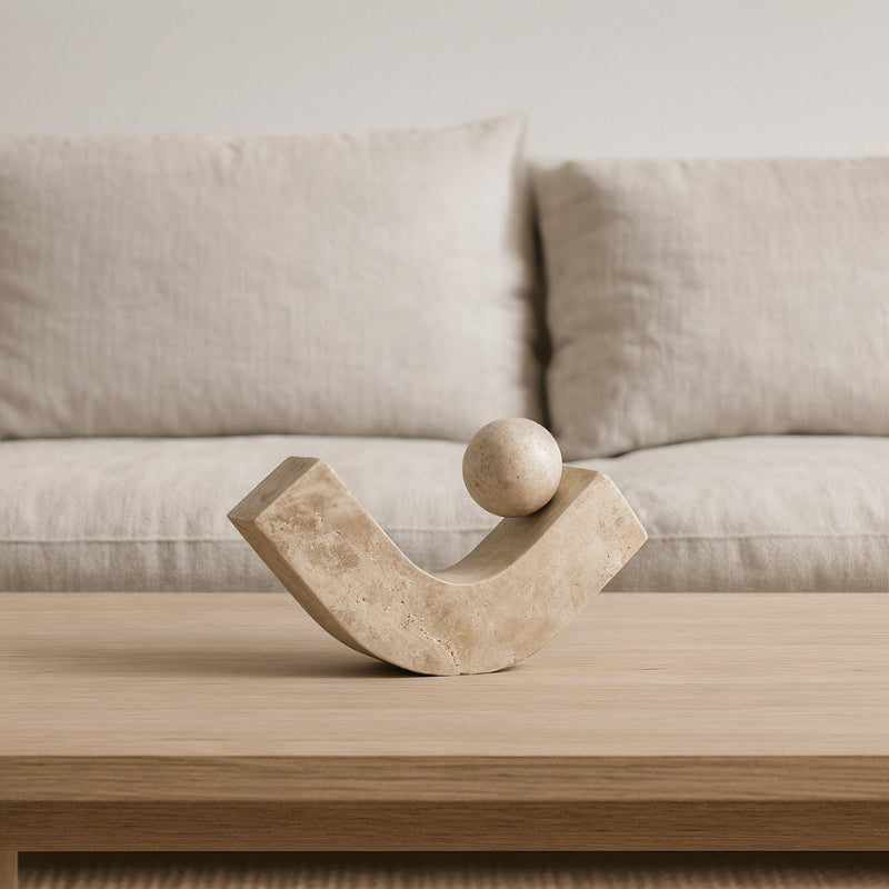 Wabi Sabi Stone sculpture on a wooden table with a beige sofa in the background