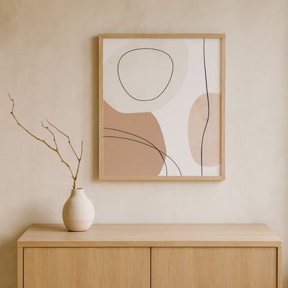 Abstract wabi sabi art​ on a wall above a wooden cabinet with a vase.