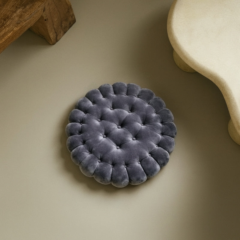 black floor cushion on a beige surface with wooden and stone elements in the background