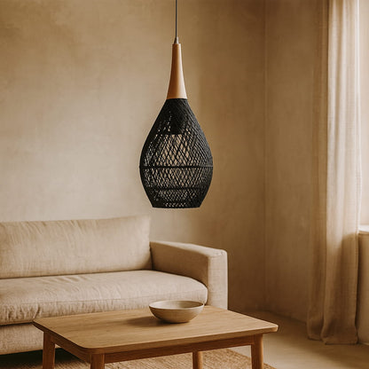 Black wicker pendant light​​​ hanging above a beige sofa and wooden coffee table in a room with beige walls and curtains.