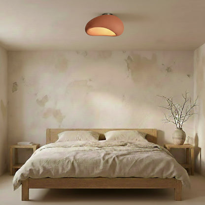 Bedroom with wooden bed, floral wallpaper, and a ceiling lamp pink​.