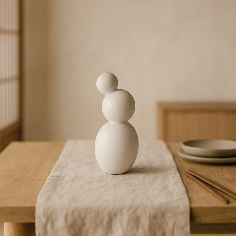 Whiteceramic vase handmade​ on a wooden table with a neutral background