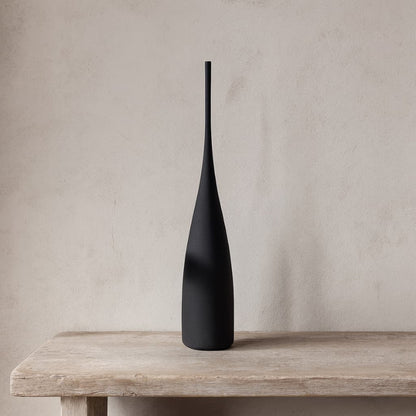 Ceramic vase tall on a wooden surface with a neutral background