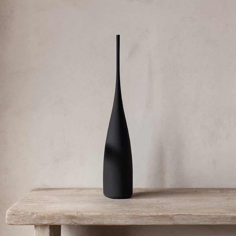 Ceramic vase tall on a wooden surface with a neutral background