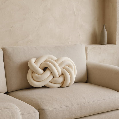 Beige cushion design for sofa​ on a beige sofa against a neutral wall.