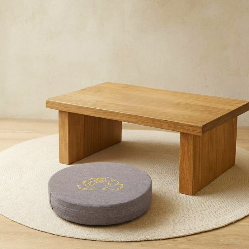 Wooden low table with a gray cushion flower lotus on a beige rug