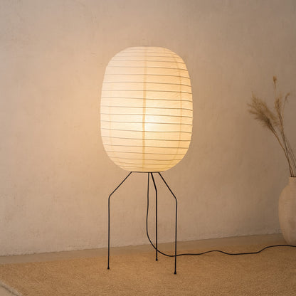 Floor lamp japandi with a paper shade on a stand against a beige wall.