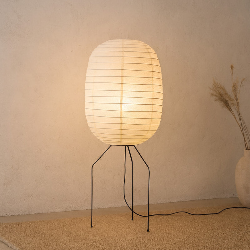 Floor lamp japandi with a paper shade on a stand against a beige wall.