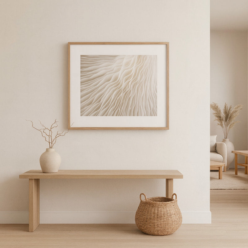 Nest living room with a wooden bench, woven basket, and framed wave pictures​ on a light wall.