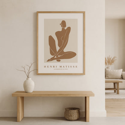 Henri Matisse prints framed on a wall with a wooden bench and vase below.
