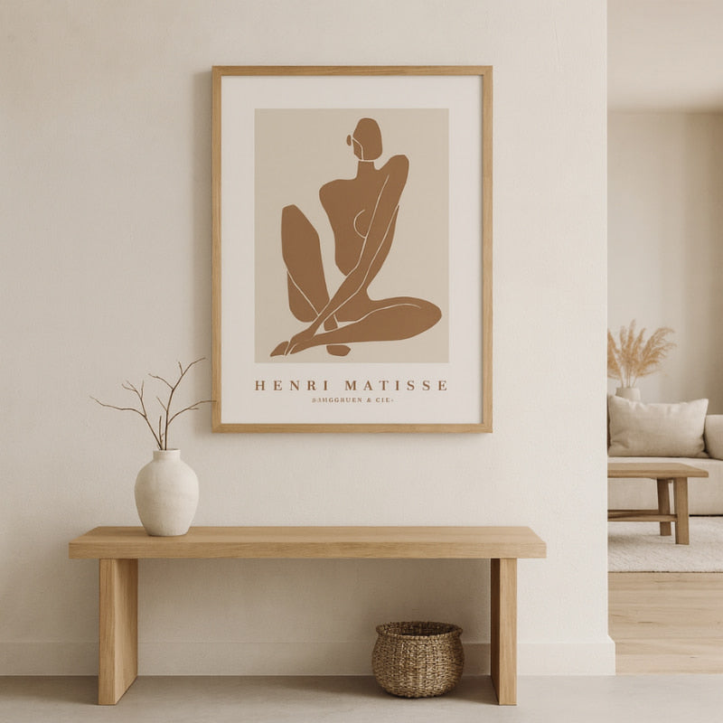 Henri Matisse prints framed on a wall with a wooden bench and vase below.