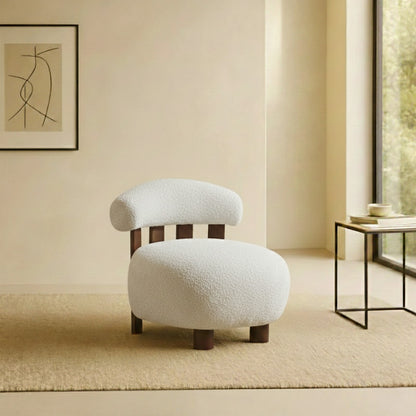 White japandi accent chair in a room with a abstract painting on the wall and a side table.