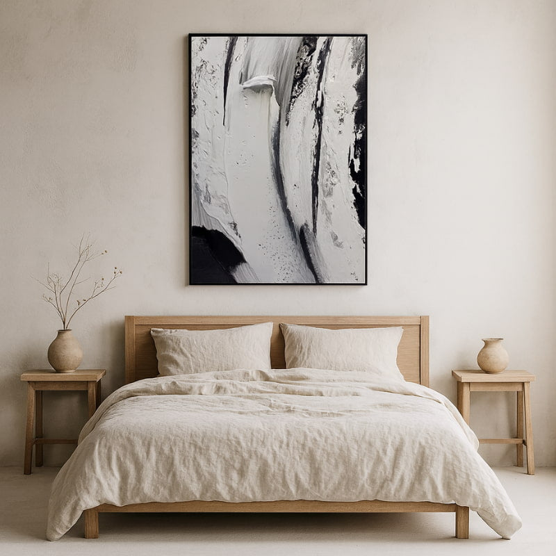 Bedroom with wooden bed, beige bedding, and large wabi sabi art​.