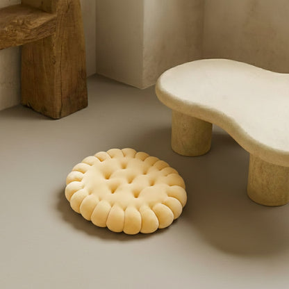 Yellow latest cushion design on a neutral floor with a stone-like stool in the background.